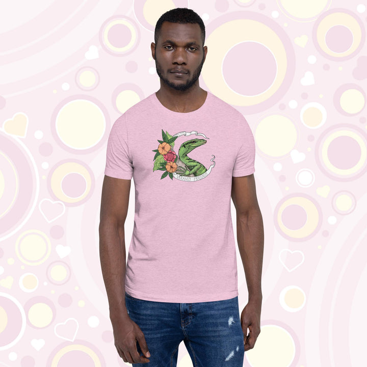 Man wearing heather prism lilac crew neck tee with a emerald tree monitor lizard in the center of a white banner with the species name on it and orange and pink flowers on the side.