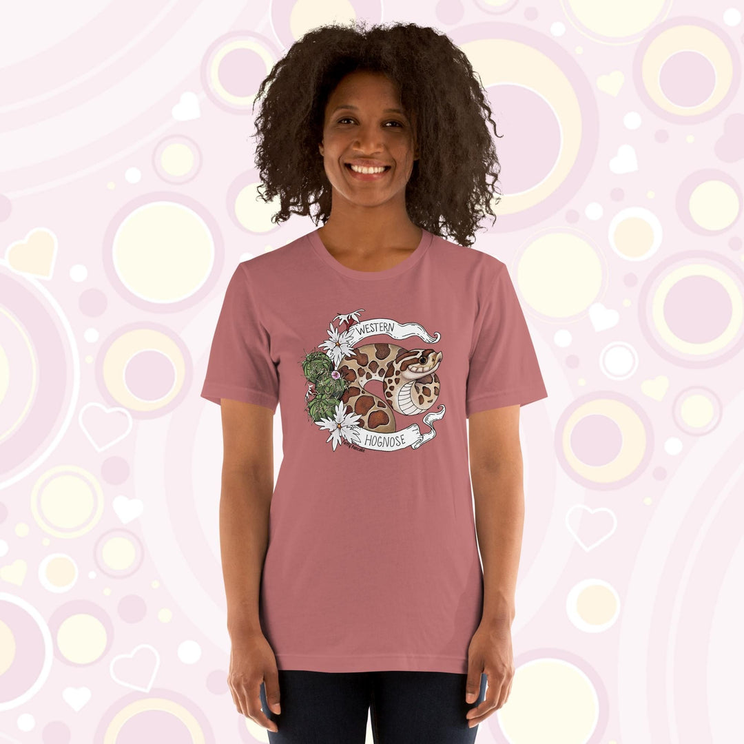 Image shows a woman wearing a mauve crew neck tee with a western hognose graphic framed with cactus and white flowers and a banner that has the text, "Western Hognose" on it.