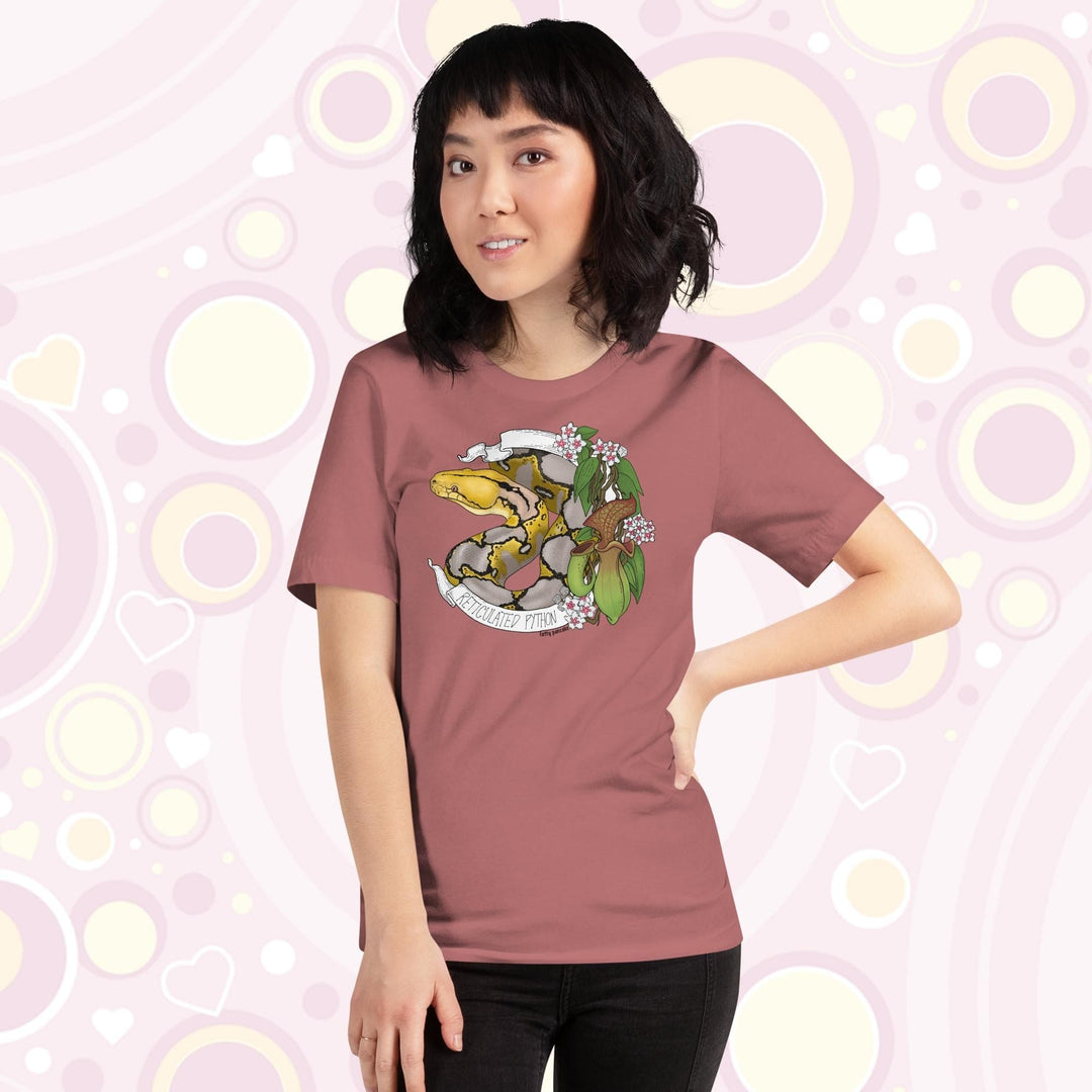 Image of a petite woman wearing a mauve crew neck tee with a normal phase reticulated python framed by pitcher plants, white flowers, and a white banner with the text, "Reticulated Python" on it.