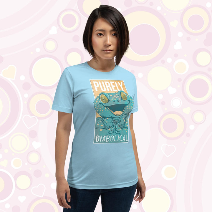 A woman wearing a ocean blue colored crew neck tee with a large mischievous looking Tokay Gecko smiling and pressing it's feet together. The text Purely Diabolical is split above and below the gecko art.