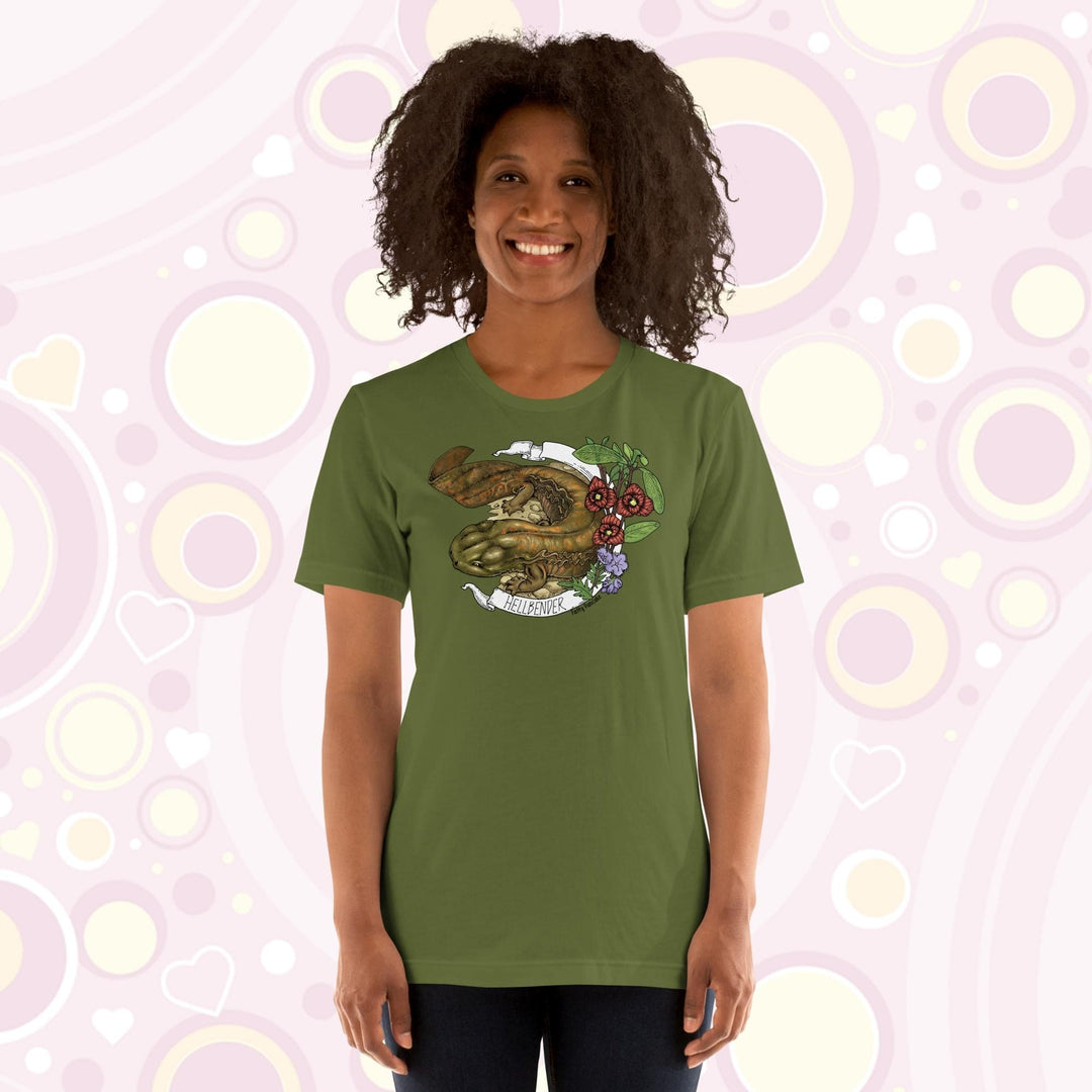 Lady wearing a olive crew neck tee with a hand drawn design of a hellbender amphibian framed by paw paw flowers and a banner that says, "Hellbender".