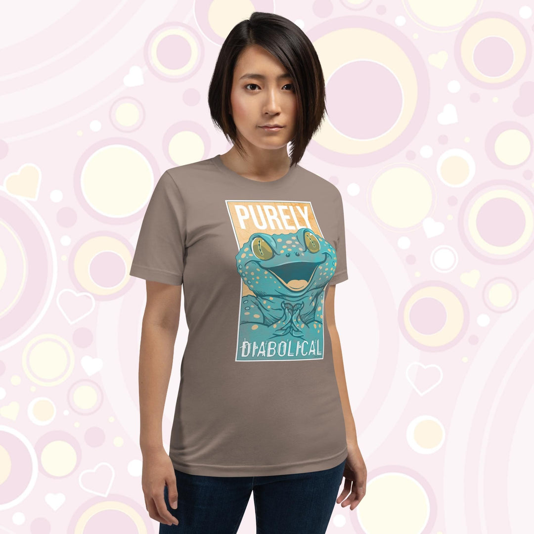 A woman wearing a pebble brown colored crew neck tee with a large mischievous looking Tokay Gecko smiling and pressing it's feet together. The text Purely Diabolical is split above and below the gecko art.