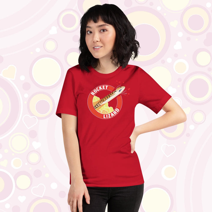 Lady wearing red crew neck tee with a circular design stating Rocket Lizard on the top and bottom and a cartoon blue tongue skink lizard blasting out from the side.