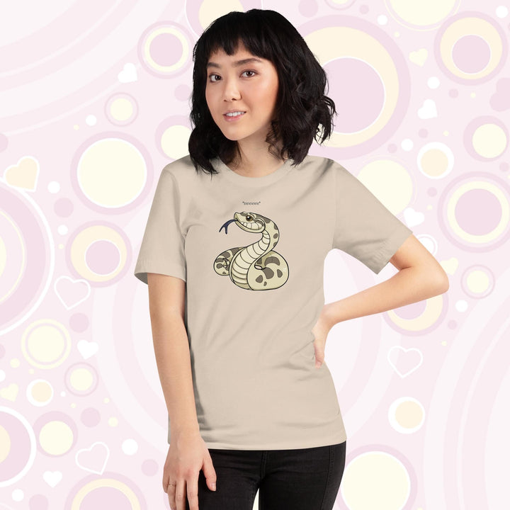 Lady wearing cream colored crew neck tee with a simple cartoony silly hognose flicking out it's tongue and saying "blelele".