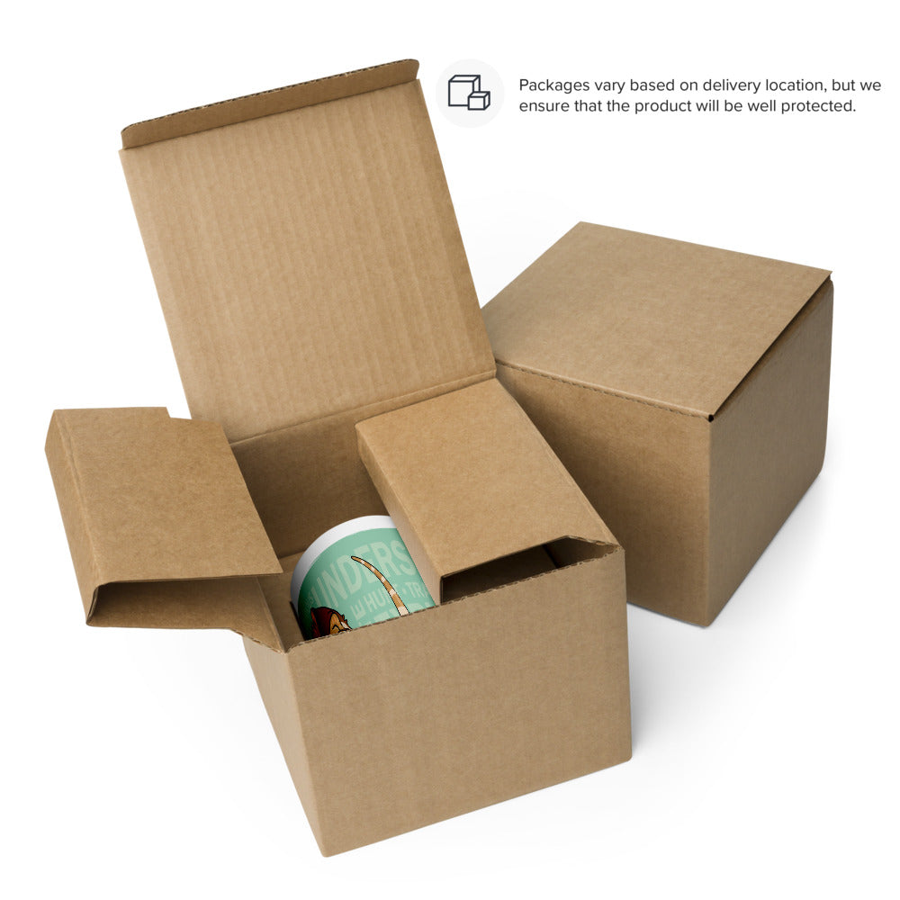 Two square brown cardboard shipping boxes, one open with the top flaps extended upward and one closed. Inside the open box, a white ceramic mug is partially visible, featuring a light green graphic with partial text.