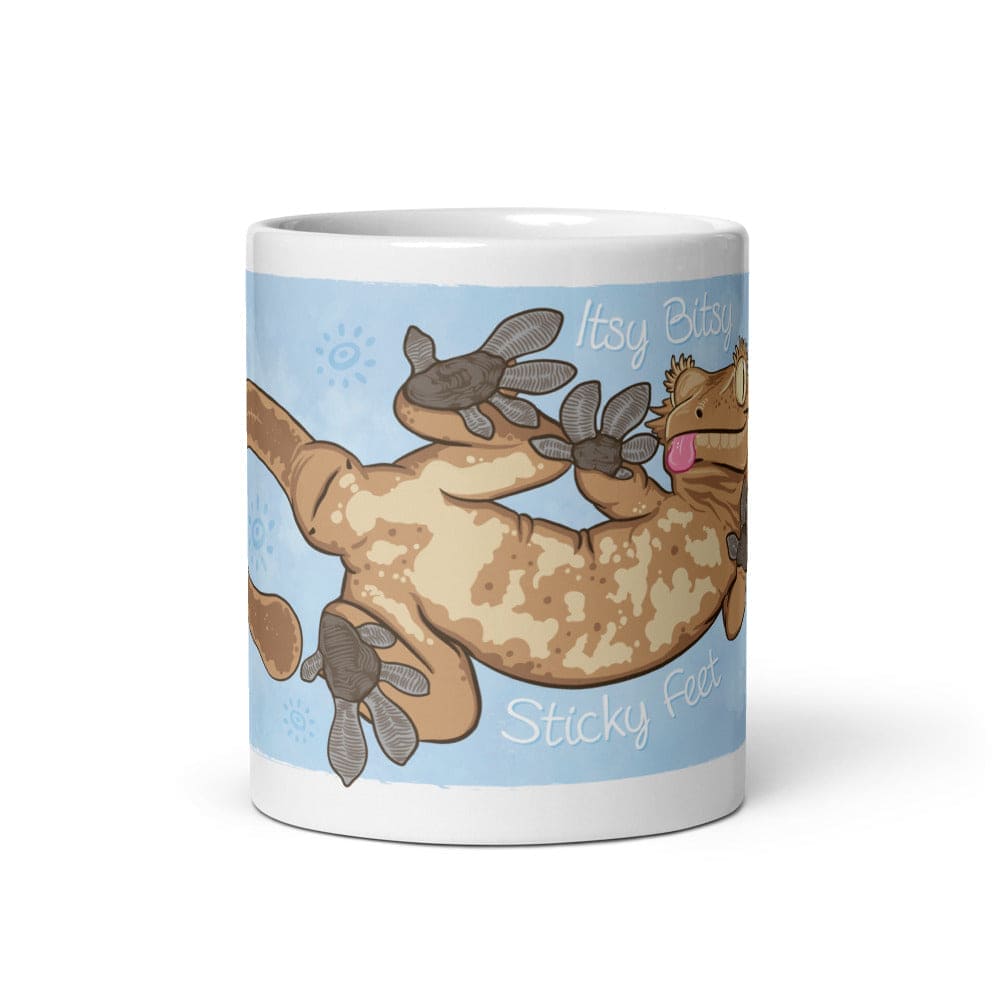 11oz mug with the front side showing the graphic for a cartoon crested gecko with Itsy Bitsy Sticky Feet on it.