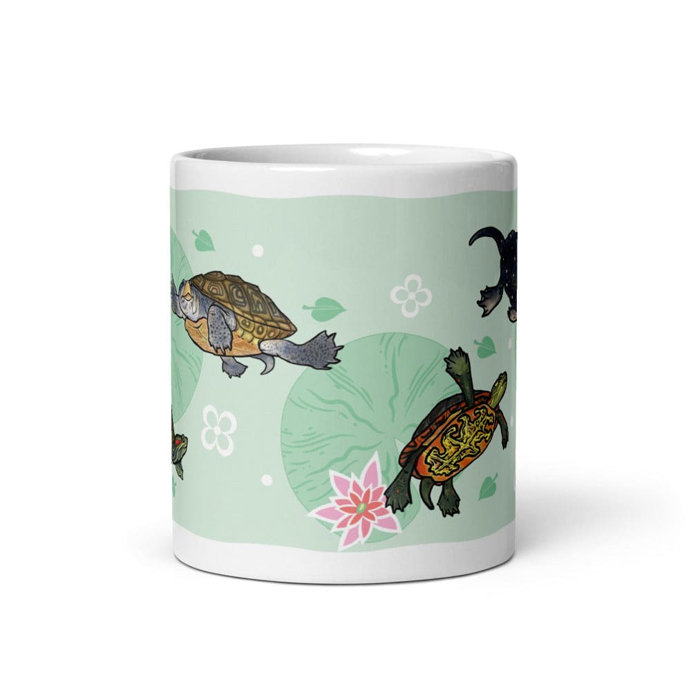 A white ceramic mug featuring a light green wrap-around design printed with cartoon turtles, lily pads, small flowers, and leaves.