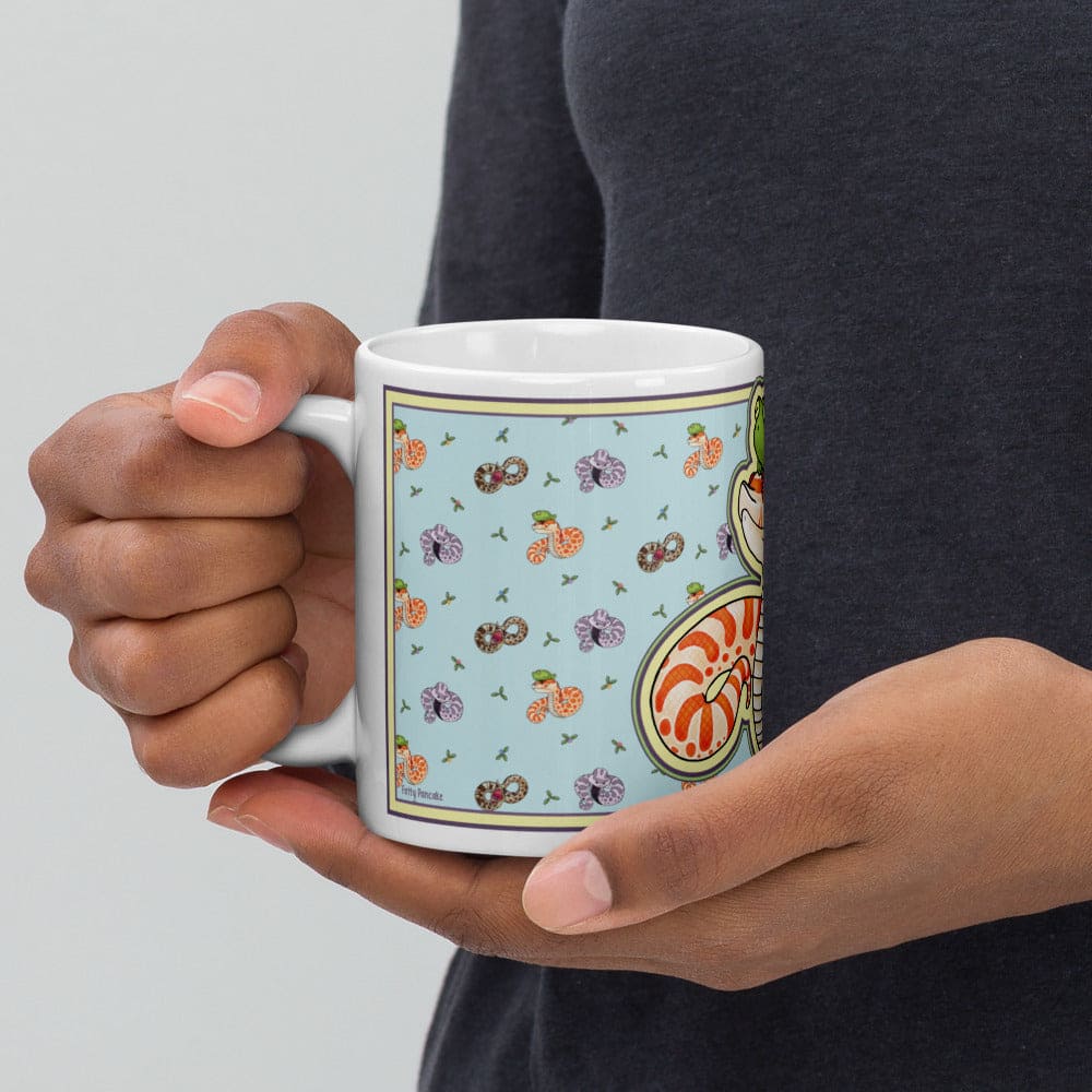 Person holding a mug with a colorful pattern on a light gray background