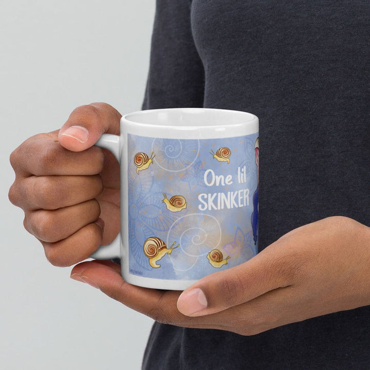 A person holding a white ceramic mug with a light blue wraparound print featuring cartoon snails and the text &