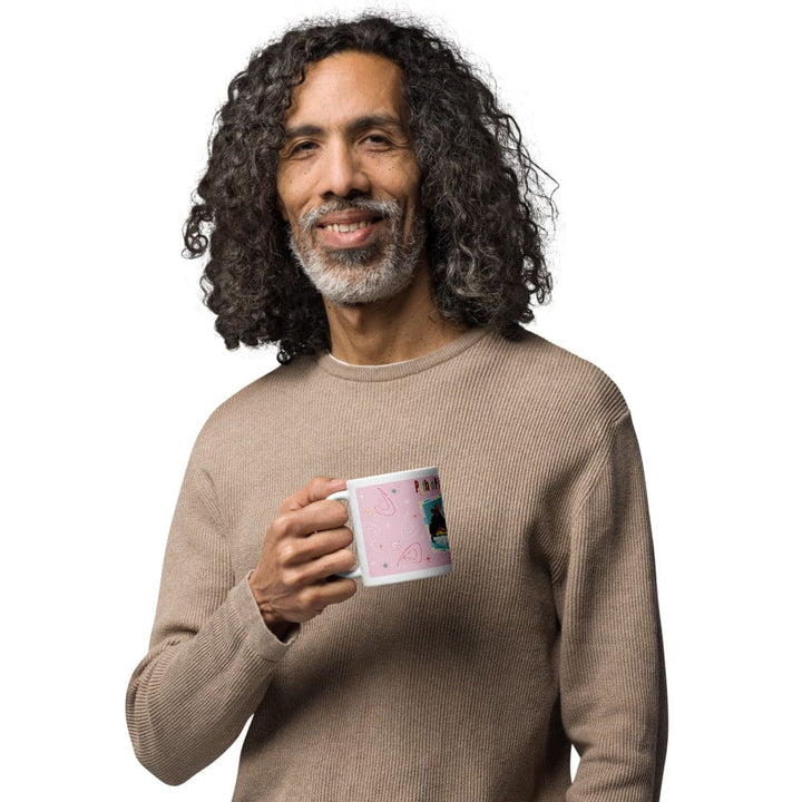 A man holding a pink mug standing against a white background.