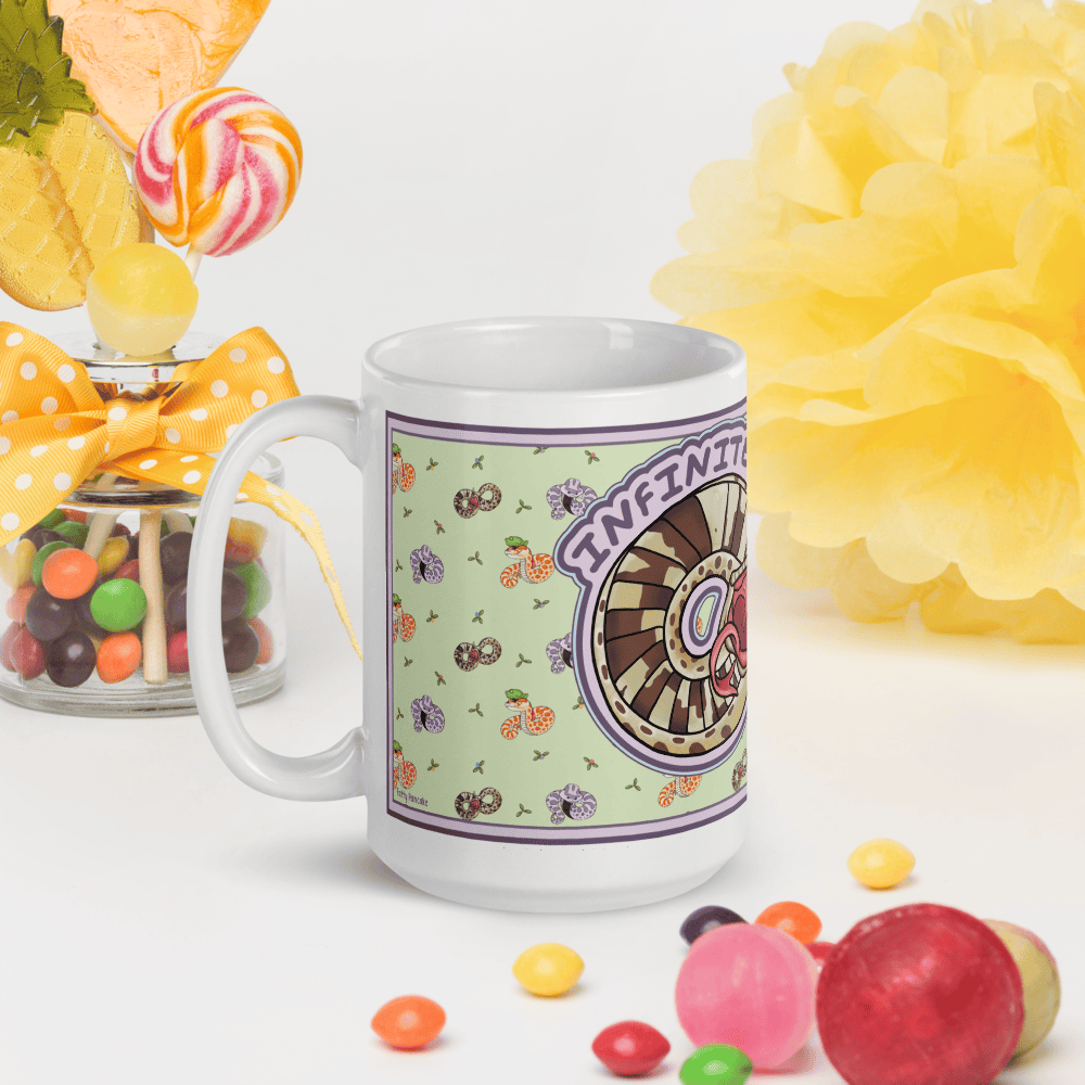 A white ceramic mug featuring a light green background with a graphic illustration of a snake coiled into an infinity symbol. The snake has brown spots and an open mouth with a pink tongue. The text "INFINITE DRAMA" is printed in purple.