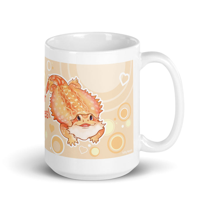 A white ceramic mug featuring a cute cartoon illustration of a bearded dragon on a warm beige background with orange, yellow, and white circular and heart accents.