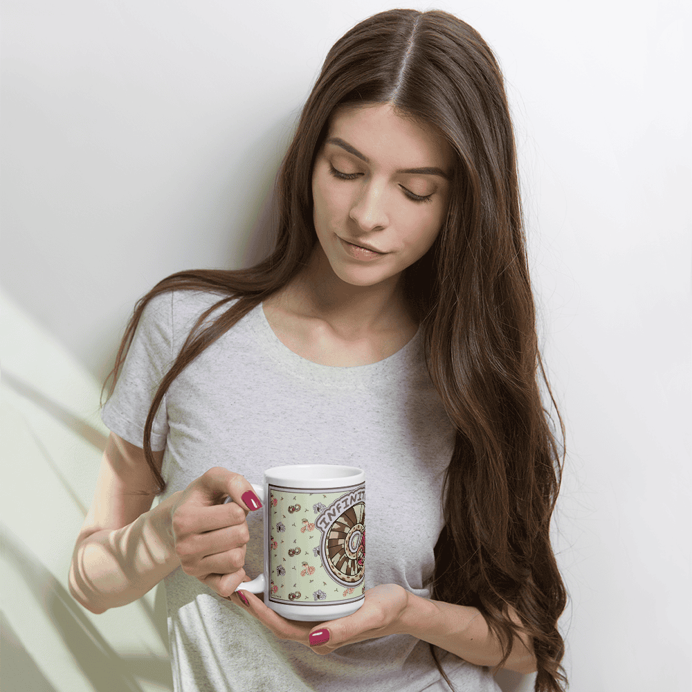 A woman holding a white ceramic mug featuring a light green background with a repeating pattern of small colorful snakes and a central circular graphic containing the word INFINITY in purple text.