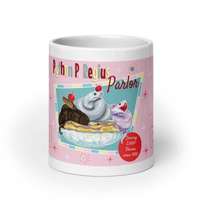 A white 20oz ceramic mug featuring a pink background with a graphic of three snakes in a glass bowl topped with cherries. The text reads Python P. Regius Parlor and Serving 2,000+ Flavors since 1900, accented with small starburst shapes.