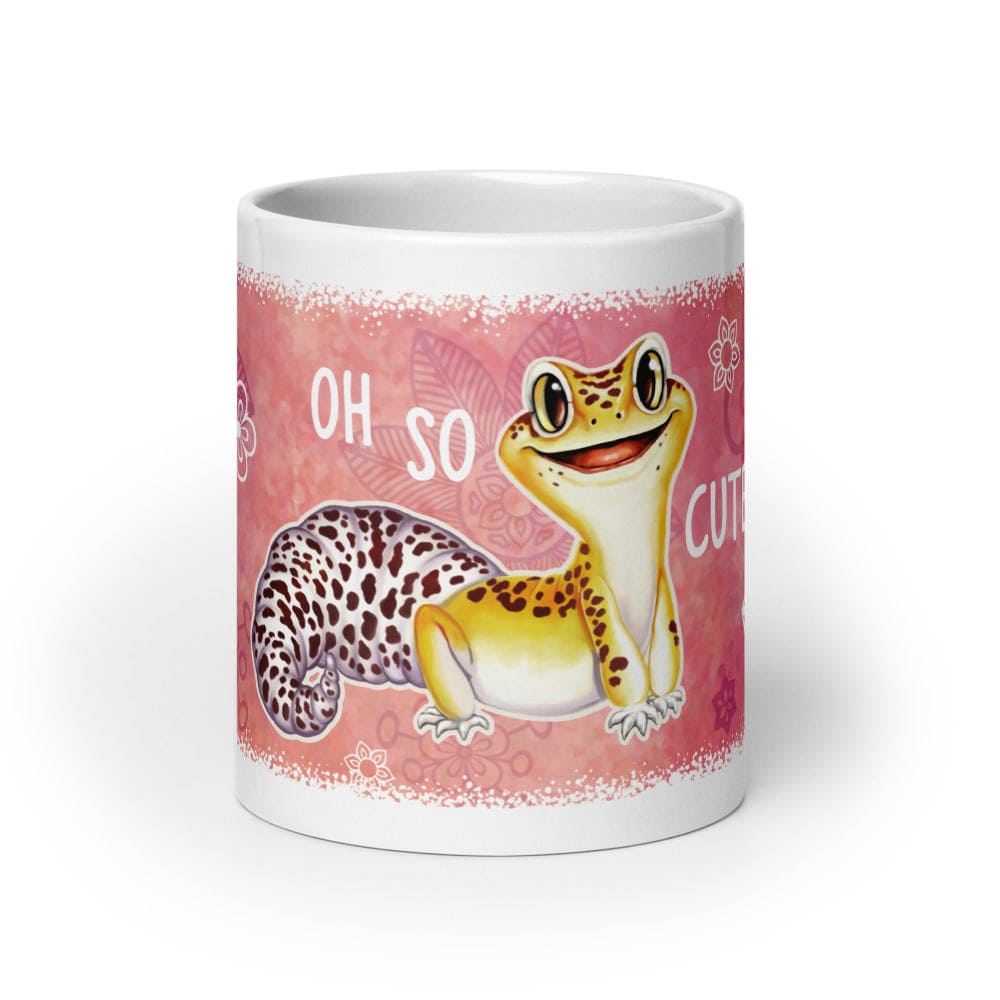 A white ceramic mug featuring a pink wraparound design with a cartoon leopard gecko and the text &