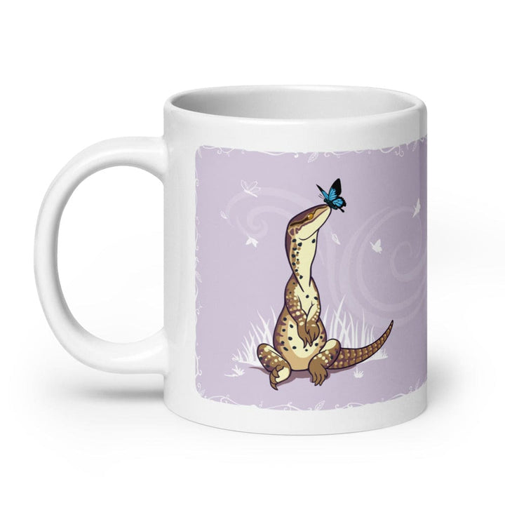 A close up a mug with an Argus monitor lizard sitting on grass with a cute butterfly sitting on it&