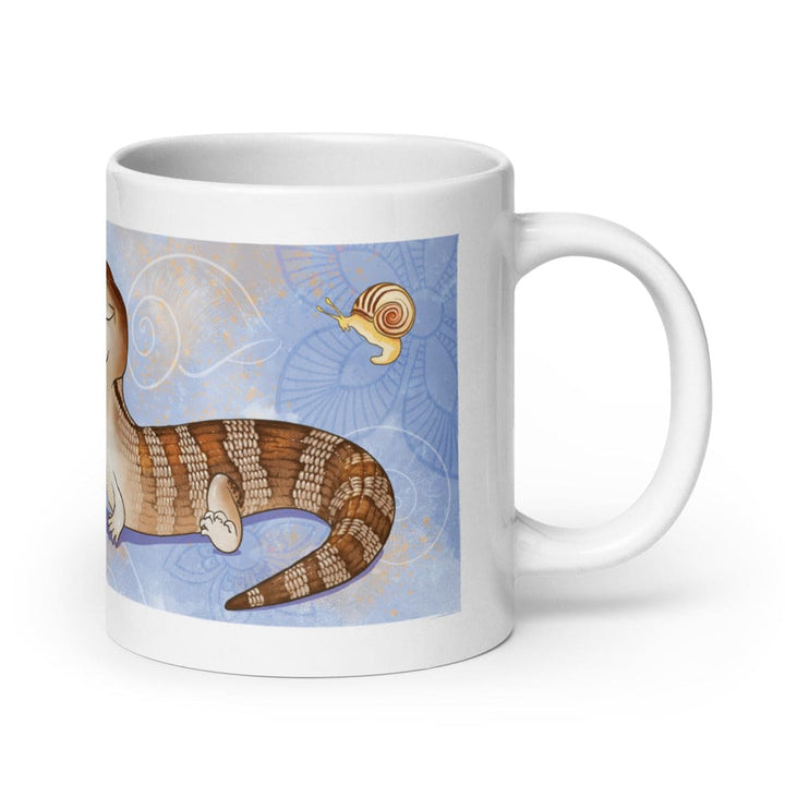 A white 20oz ceramic mug featuring a colorful illustration of a brown and tan striped blue-tongued skink lizard with a small snail nearby. The background is a light blue shade with subtle white line art patterns and gold accents. This depicts the side of the mug with the handle on the right.