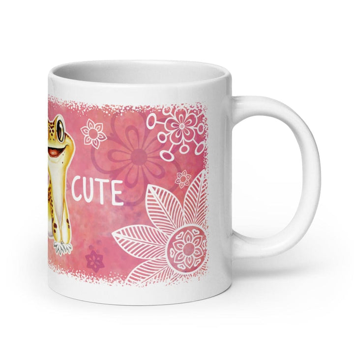 A white ceramic mug featuring a pink and red watercolor-style graphic with a cartoon leopard gecko, white floral line art, and the word &